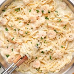 Creamy shrimp alfredo pasta mixed in a skillet with tender shrimp and fettuccine.