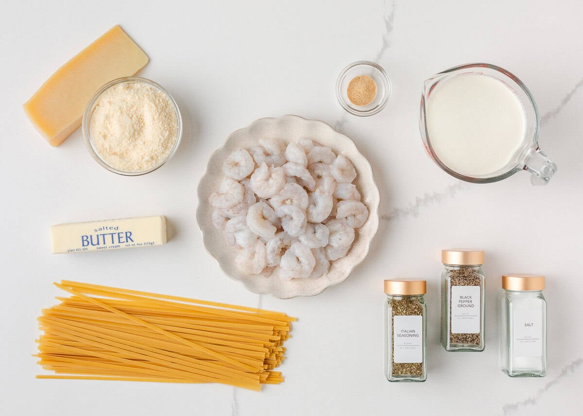 Just a few simple ingredients come together to create this rich and creamy shrimp fettuccine alfredo, ready in 25 minutes! Ingredients for shrimp fettuccine alfredo including raw shrimp, fettuccine pasta, butter, heavy cream, Parmesan cheese, and seasonings.