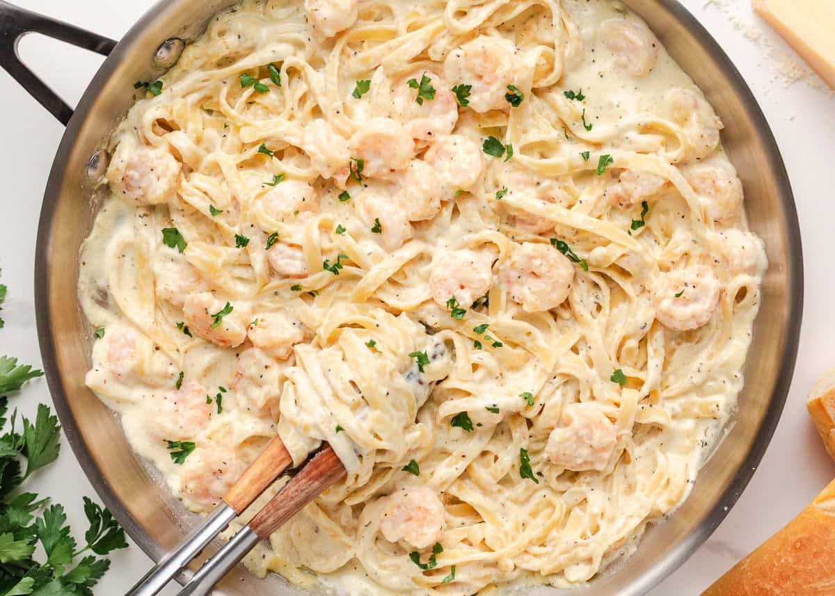 Just a few simple ingredients come together to create this rich and creamy shrimp fettuccine alfredo, ready in 25 minutes! Creamy shrimp alfredo pasta mixed in a skillet with tender shrimp and fettuccine.