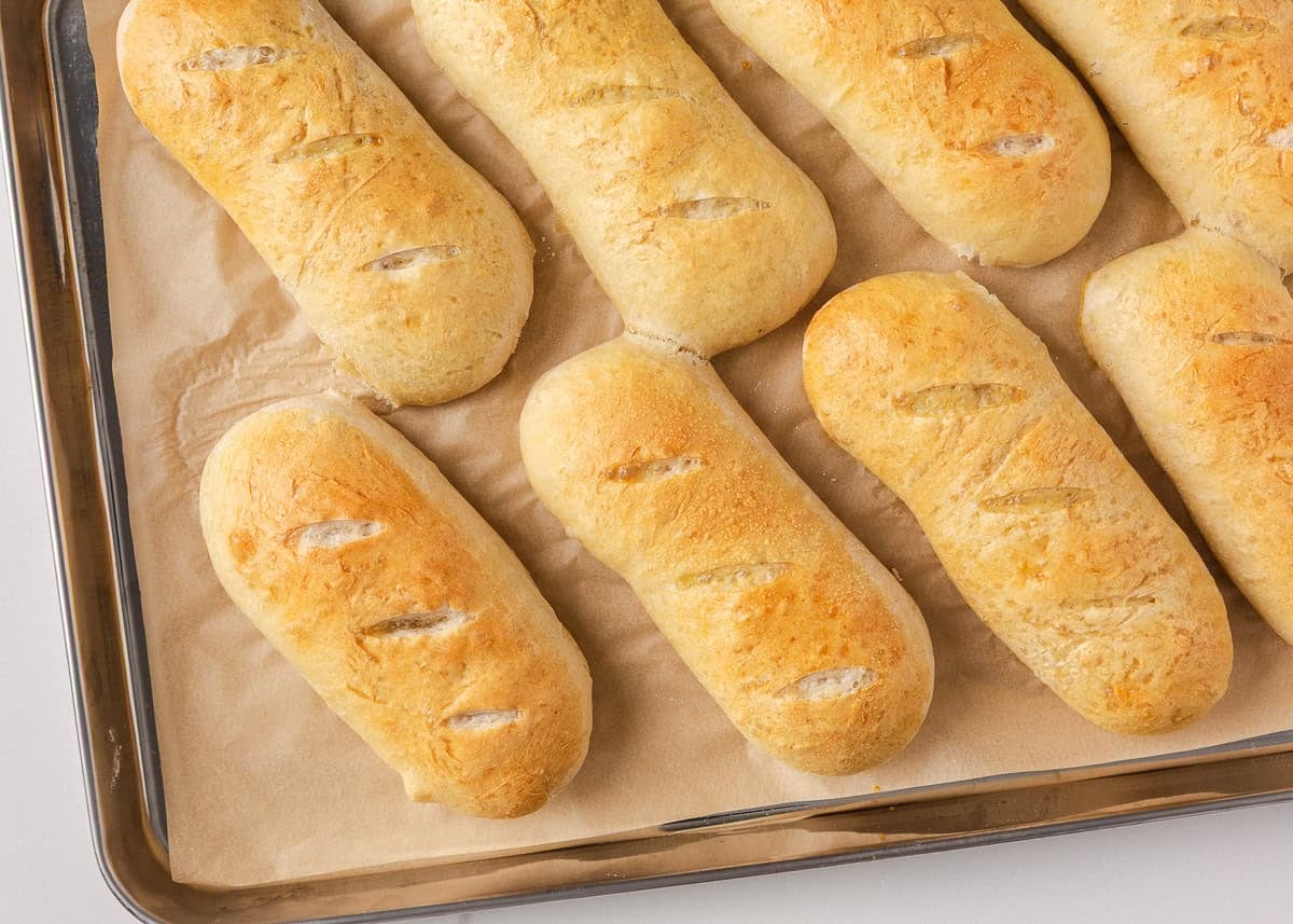 Soft on the inside with a golden, chewy crust, these homemade hoagie rolls are easy to make and instantly upgrade your favorite subs and sandwiches. Freshly baked homemade hoagie rolls with golden brown tops cooling on a baking sheet.