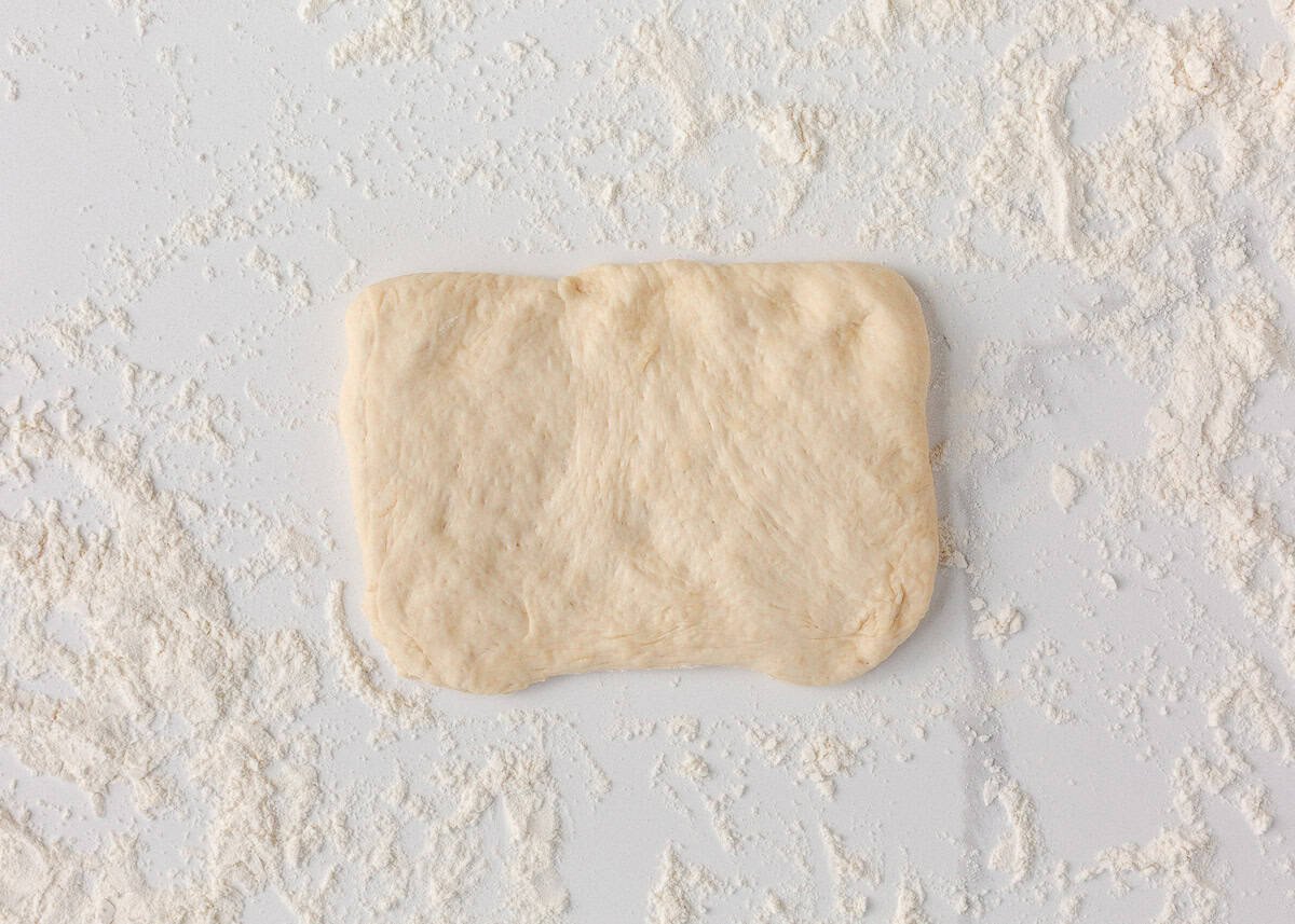 Soft on the inside with a golden, chewy crust, these homemade hoagie rolls are easy to make and instantly upgrade your favorite subs and sandwiches. Hoagie roll dough pressed into a rectangle on a floured surface before shaping.