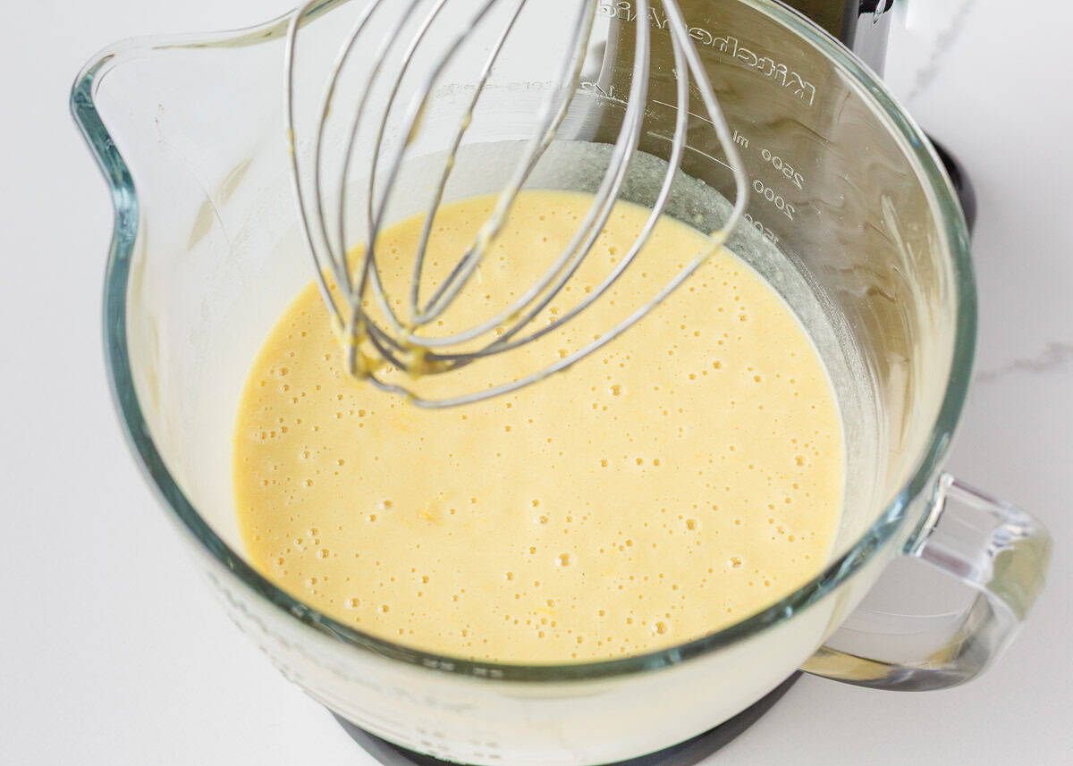 This lemon olive oil cake is sunshine in dessert form, with a light, tender crumb and bright lemon flavor in every bite. Elegant yet simple, it’s an effortless cake to make. Whisking lemon olive oil cake batter until smooth in a glass mixing bowl