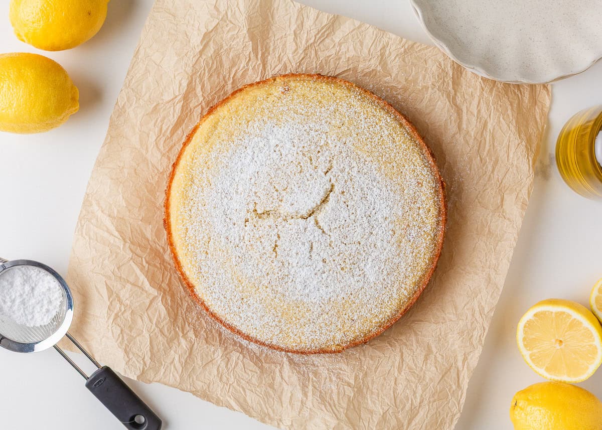 This lemon olive oil cake is sunshine in dessert form, with a light, tender crumb and bright lemon flavor in every bite. Elegant yet simple, it’s an effortless cake to make. Whole lemon olive oil cake dusted with powdered sugar and surrounded by fresh lemons.