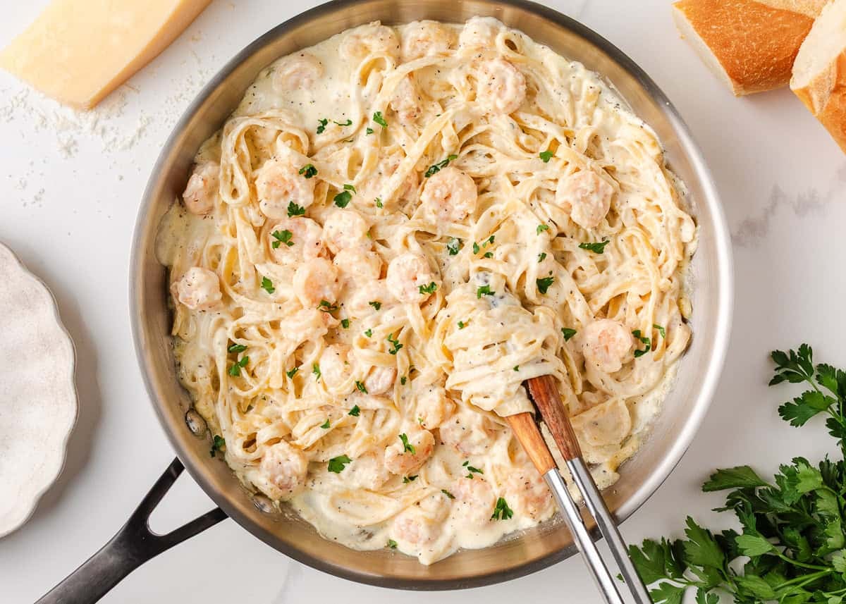 Just a few simple ingredients come together to create this rich and creamy shrimp fettuccine alfredo, ready in 25 minutes! Shrimp fettuccine alfredo tossed in a creamy Parmesan sauce and garnished with parsley.