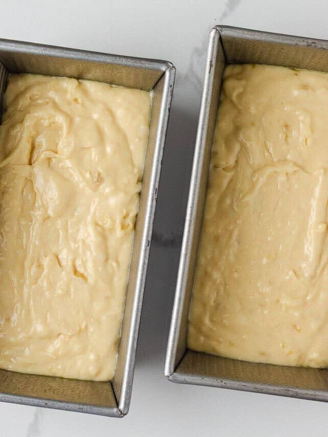 This sour cream banana bread is extra soft, moist, and full of flavor thanks to one simple ingredient. It’s an easy recipe and the perfect way to use up overripe bananas. Sour cream banana bread batter divided into two loaf pans.