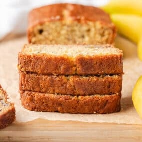 Thick slices of banana sour cream bread with a golden crust and soft center.