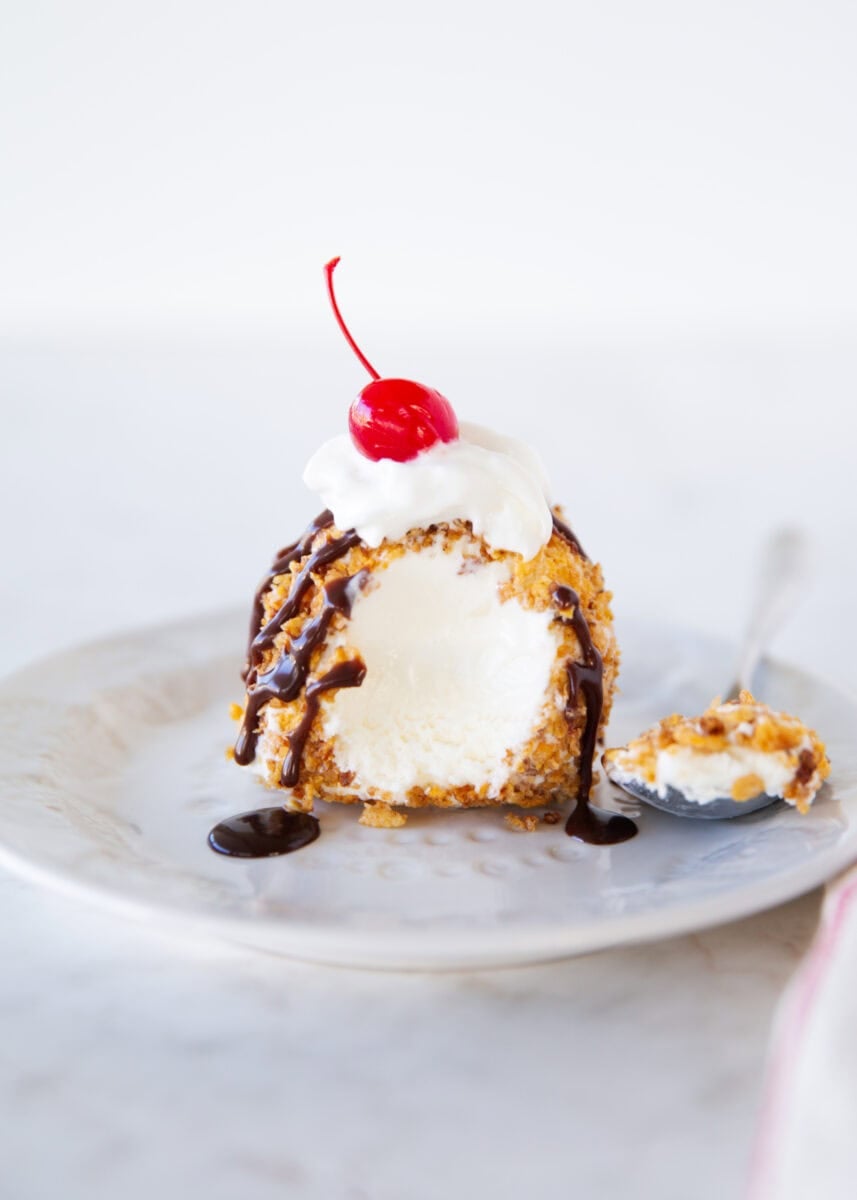 This fried ice cream recipe is made without deep frying, so it’s easy, mess-free, and just as crunchy as your favorite Mexican restaurant dessert. Cut open fried ice cream showing creamy vanilla center and crispy cinnamon cereal coating.