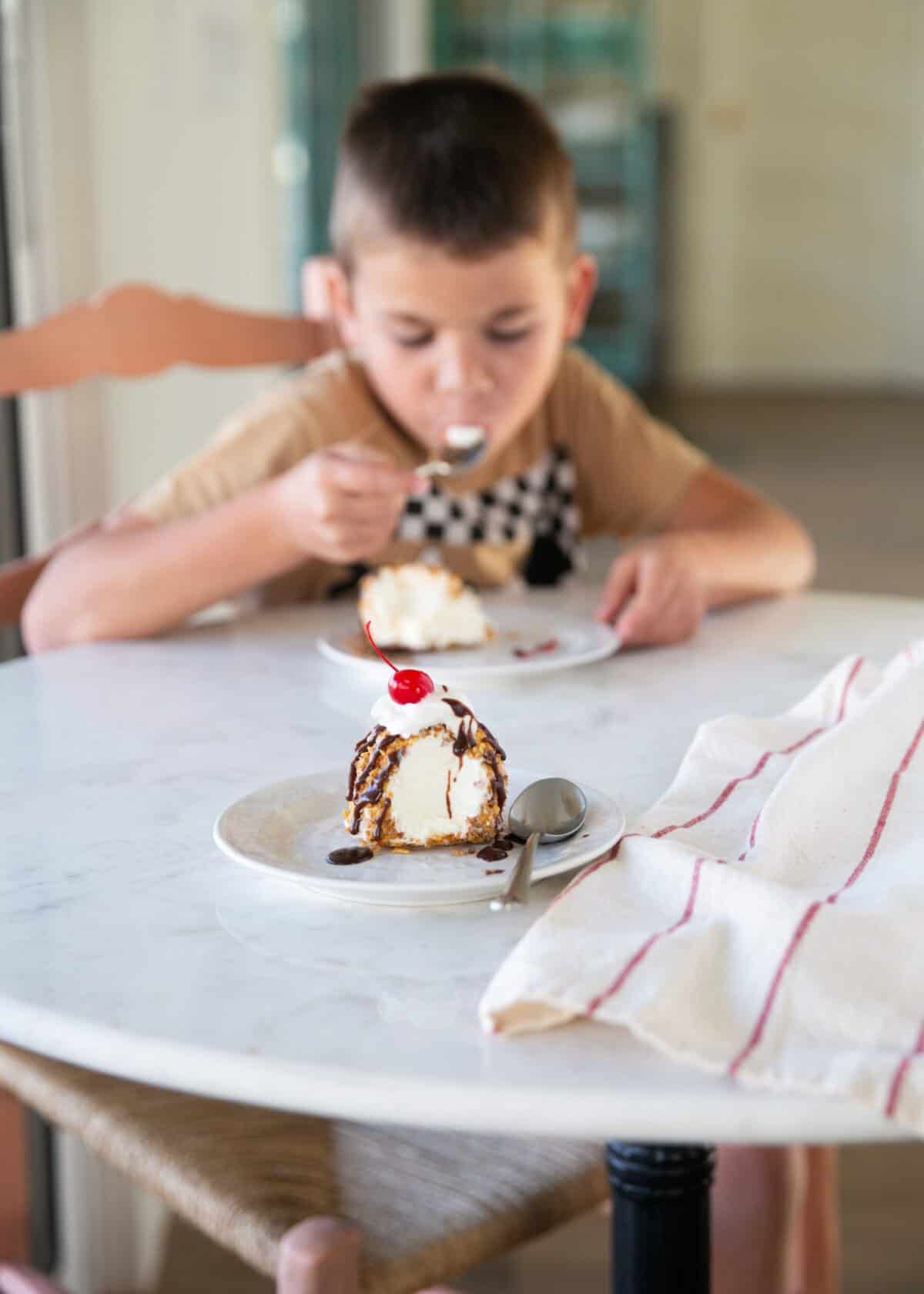 This fried ice cream recipe is made without deep frying, so it’s easy, mess-free, and just as crunchy as your favorite Mexican restaurant dessert. Wes enjoying homemade fried ice cream topped with chocolate sauce and whipped cream.