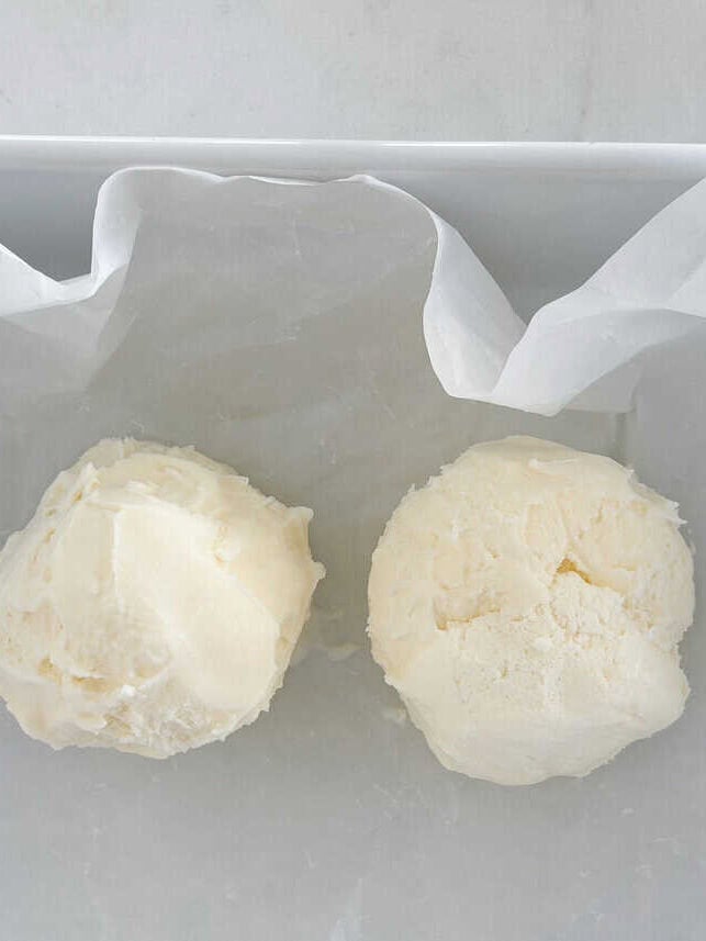 This fried ice cream recipe is made without deep frying, so it’s easy, mess-free, and just as crunchy as your favorite Mexican restaurant dessert. Scoops of vanilla ice cream placed on parchment-lined tray before freezing for fried ice cream.