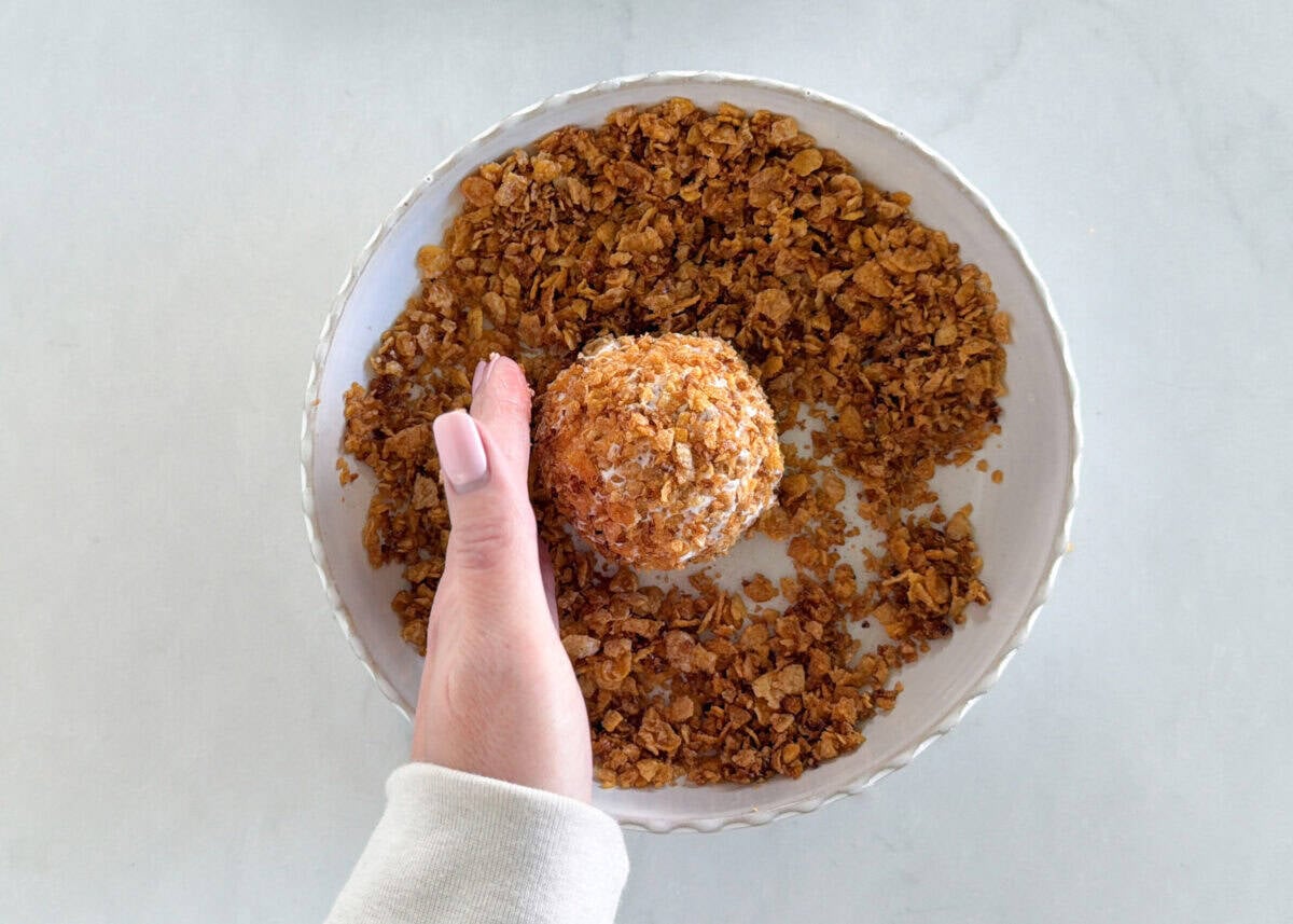 This fried ice cream recipe is made without deep frying, so it’s easy, mess-free, and just as crunchy as your favorite Mexican restaurant dessert. Pressing toasted cereal mixture onto frozen ice cream ball to make fried ice cream.