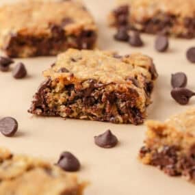 Oatmeal cookie bar showing a soft, gooey center with chocolate chips and golden edges.