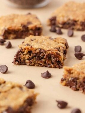 Oatmeal cookie bar showing a soft, gooey center with chocolate chips and golden edges.