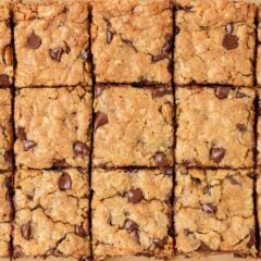 Freshly baked oatmeal cookie bars cut into squares with melted chocolate chips throughout.