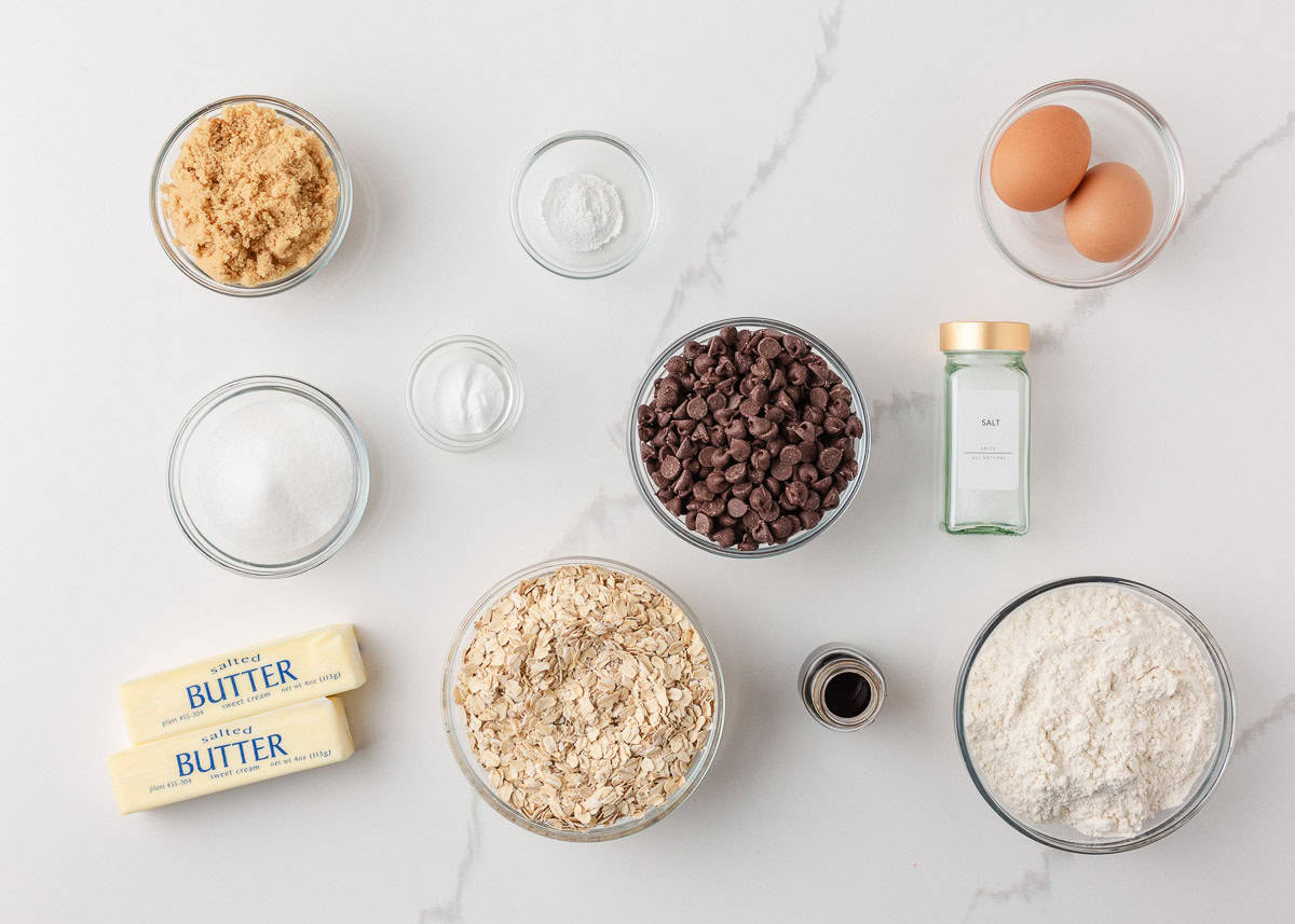 Loaded with oats, brown sugar, and melty chocolate chips, these oatmeal cookie bars are thick, chewy, and made in a single batch. No cookie scoop required! Ingredients for oatmeal chocolate chip cookie bars including oats, flour, butter, eggs, sugar, and chocolate chips.