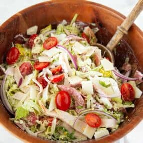 Italian grinder salad with deli meat and cheese tossed with lettuce, tomatoes, and onions.
