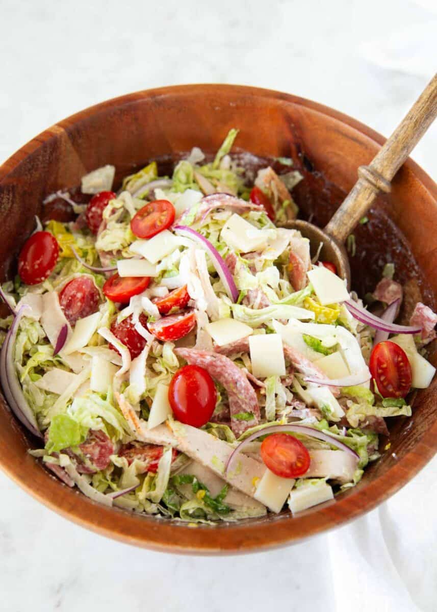 This Italian grinder salad takes the fresh flavors of my favorite sub sandwich and tosses them in a creamy, tangy dressing for an easy, low carb meal that’s deliciously filling. Italian grinder salad with deli meat and cheese tossed with lettuce, tomatoes, and onions.