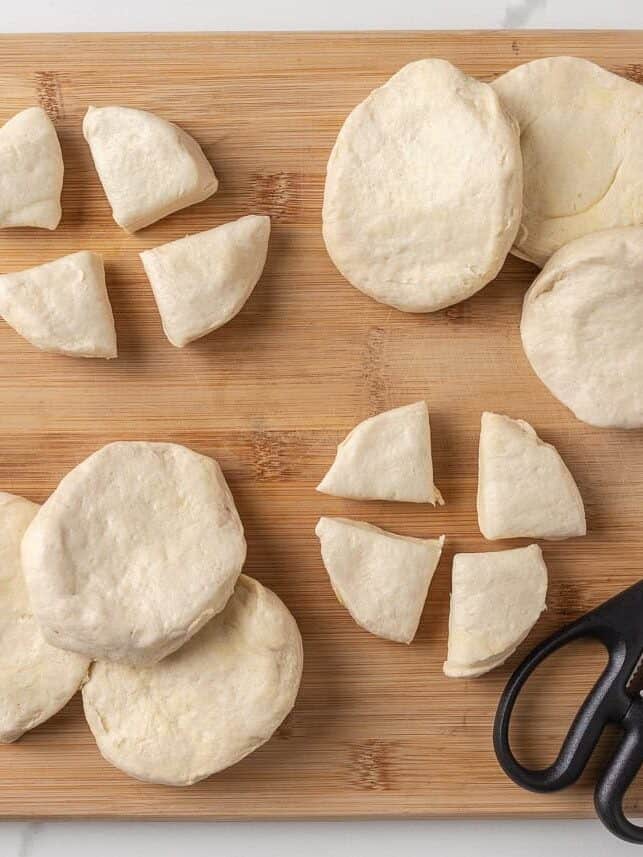 This bubble pizza is an easy way to make pizza at home without the hassle of rolling out dough. Baked into a fun pull-apart style, it’s packed with crowd-pleasing pizza flavor! Biscuit dough cut into pieces for making bubble pizza.