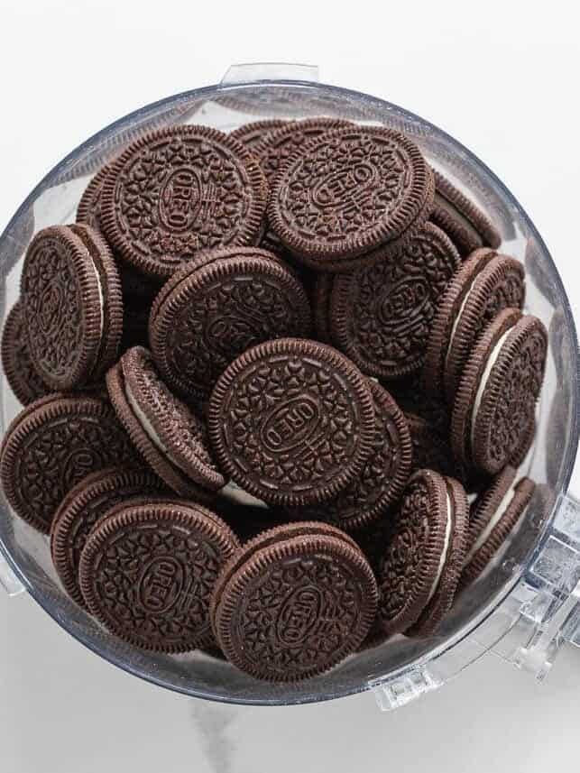 Whole Oreos in a food processor bowl before crushing into crumbs for the Oreo crust.