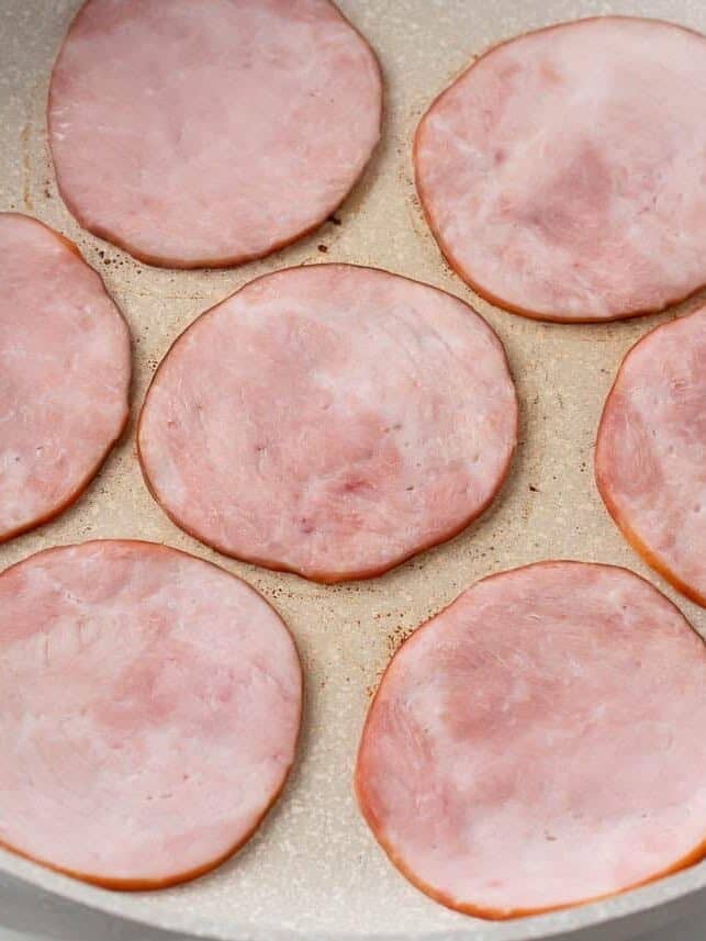 Canadian bacon in a skillet.