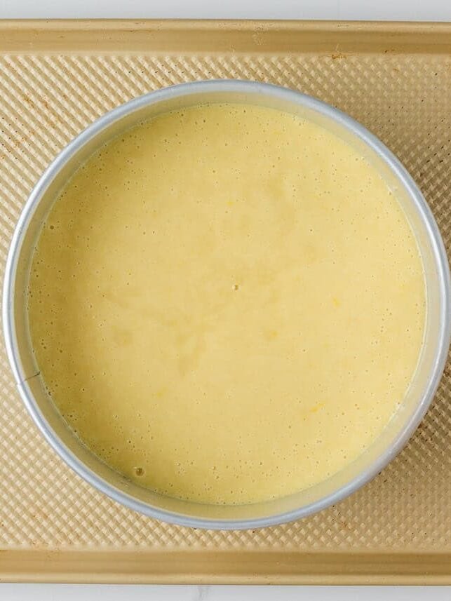 This lemon olive oil cake is sunshine in dessert form, with a light, tender crumb and bright lemon flavor in every bite. Elegant yet simple, it’s an effortless cake to make. Lemon olive oil cake batter poured into a prepared round cake pan before baking