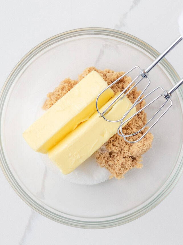 Loaded with oats, brown sugar, and melty chocolate chips, these oatmeal cookie bars are thick, chewy, and made in a single batch. No cookie scoop required! Creaming butter and sugars in a bowl.