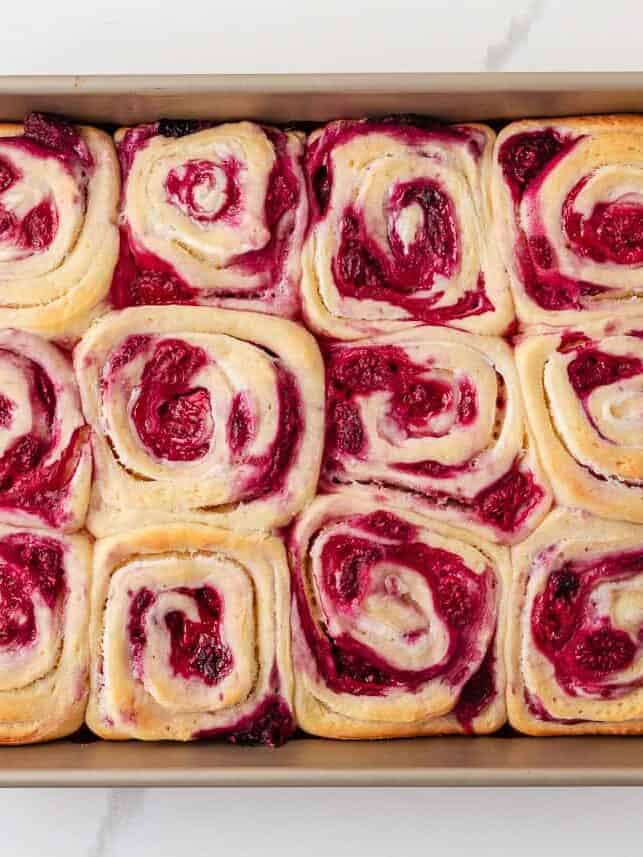 These raspberry sweet rolls are an indulgent breakfast treat made with soft yeast dough, a swirled frozen raspberry filling, and thick cream cheese frosting! Freshly baked raspberry rolls before frosting.