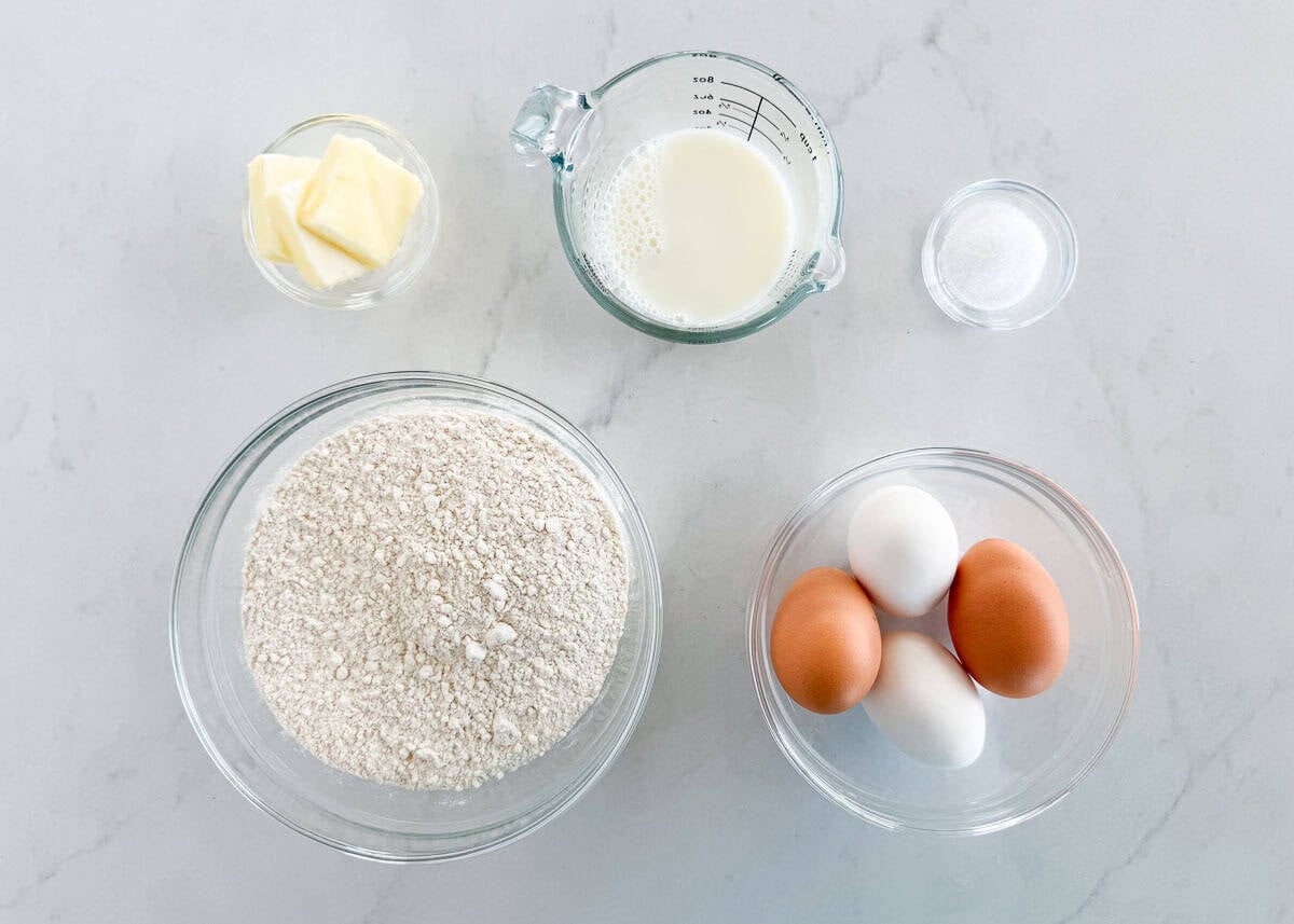 Learn to make homemade German spaetzle that's soft, chewy, and on the table in under 30 minutes. So good with brown butter, gravy, or cheese. Spaetzle ingredients on a counter: flour, eggs, milk, butter, and salt.