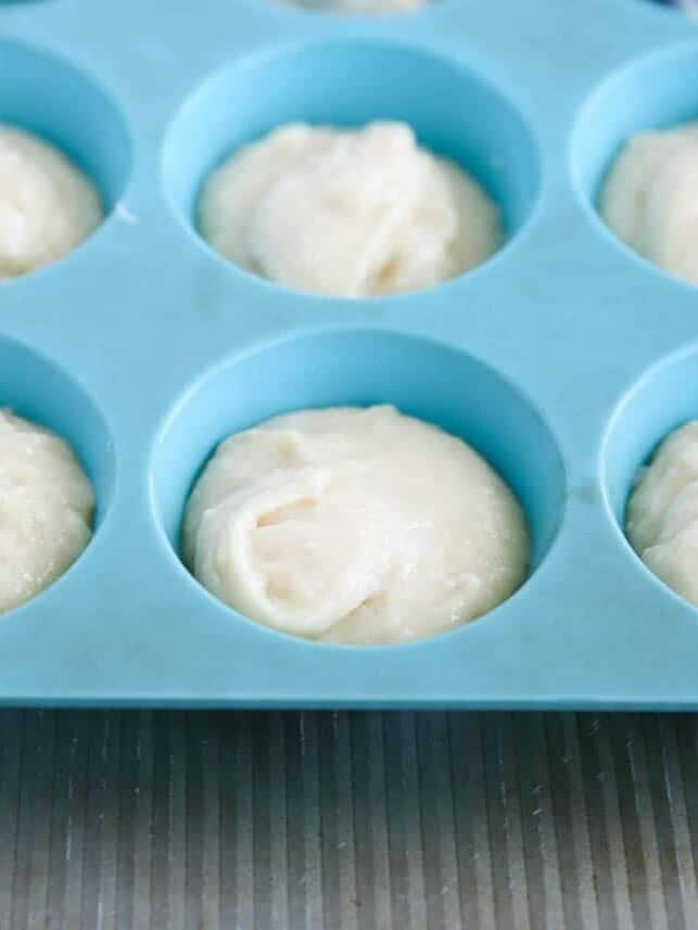 A blue muffin tin with muffin batter.