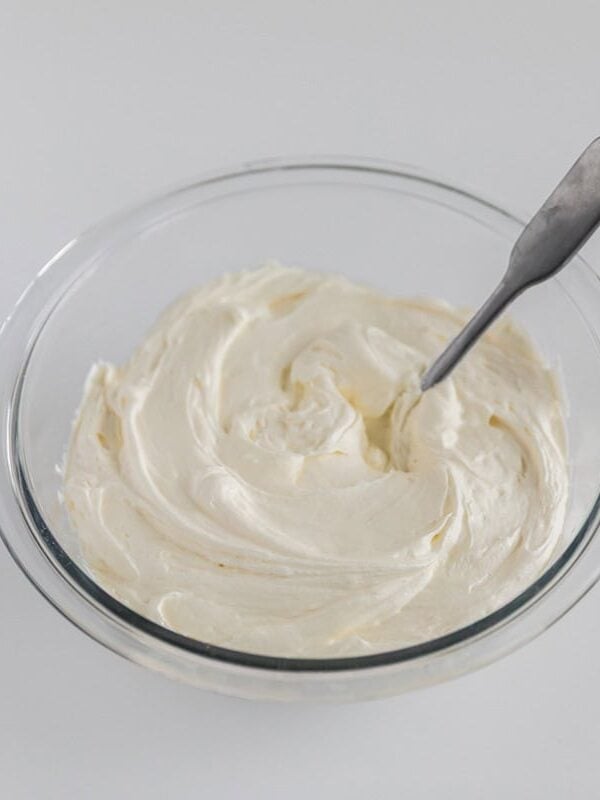 Cream cheese and Cool Whip filling mixed together in a glass bowl for strawberry pretzel salad.
