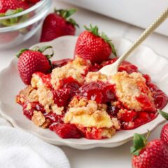 Close up of strawberry cheesecake dump cake with creamy cheesecake layer and juicy strawberry filling.