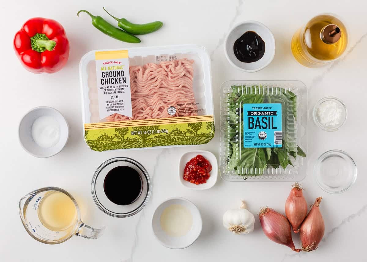 This easy Thai basil chicken recipe is bold, savory, and ready in under 30 minutes. It's everything you love about your favorite Thai food, made right at home! Ingredients for Thai basil chicken including ground chicken, basil, peppers, garlic, shallots, and sauces.
