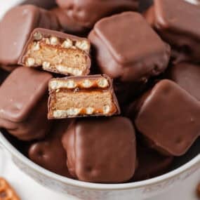 Close-up overhead angle of copycat take 5 candy bars, with two halved pieces showing the chewy, crunchy layers inside.