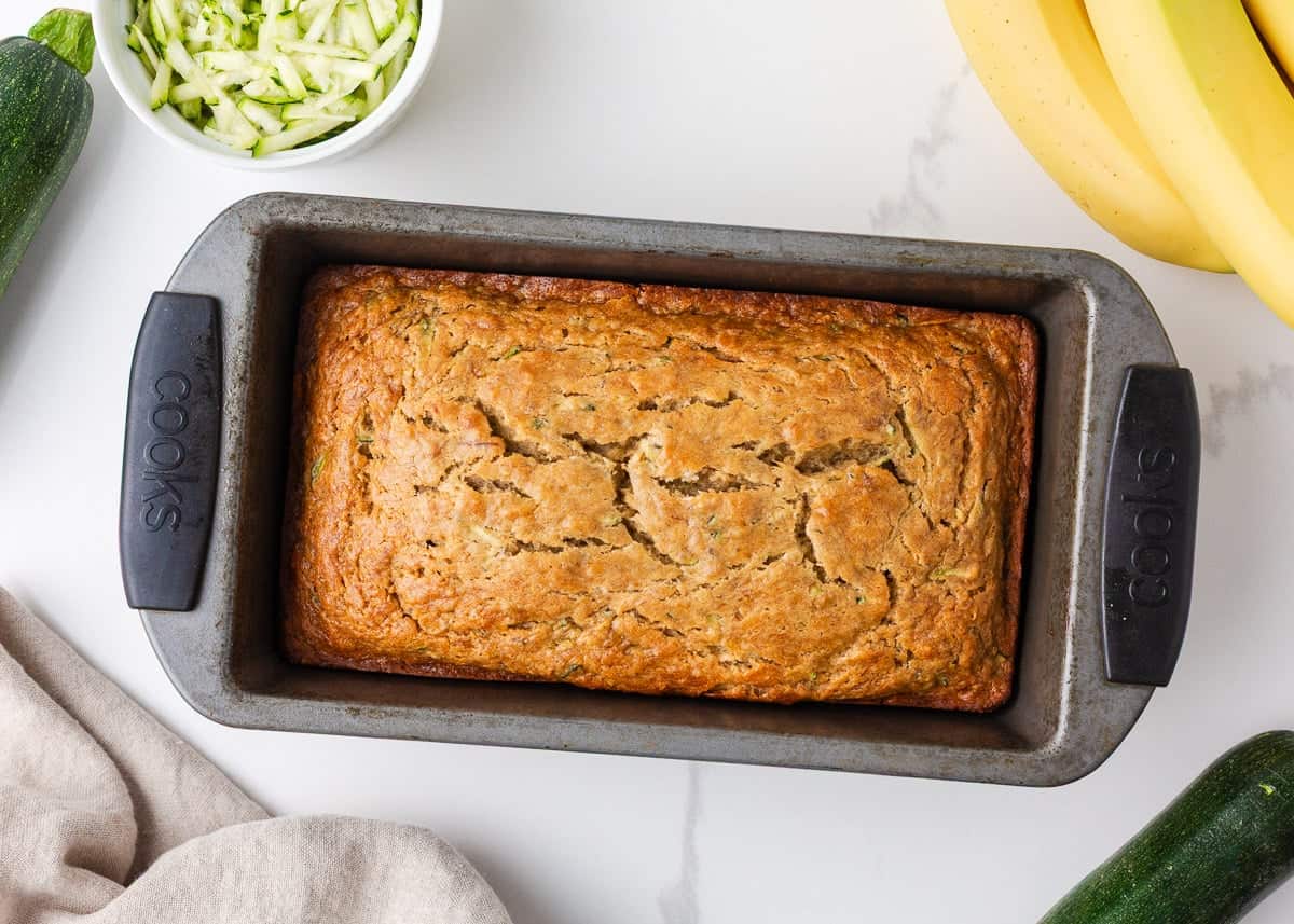 Moist, tender, and packed with flavor, this zucchini banana bread is a delicious way to use up ripe bananas and fresh zucchini in one easy loaf! Freshly baked zucchini banana bread cooling in a loaf pan.
