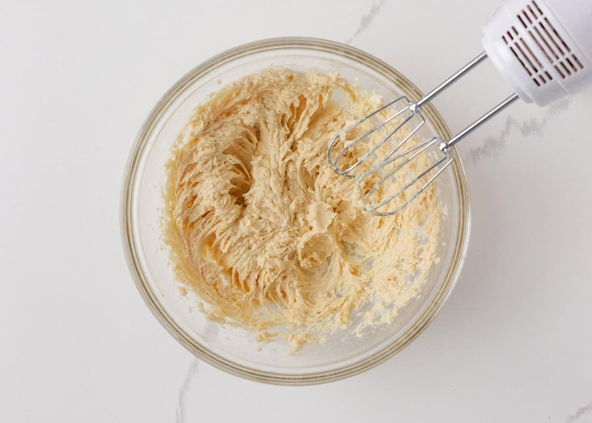 Creamed butter and sugar mixture light and fluffy for soft orange cookies dough.