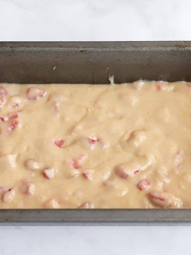 Strawberry quick bread batter spread evenly in a loaf pan before baking..