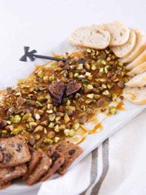 Boursin cheese fig dip with pistachios, hot honey, baguette slices and bread.