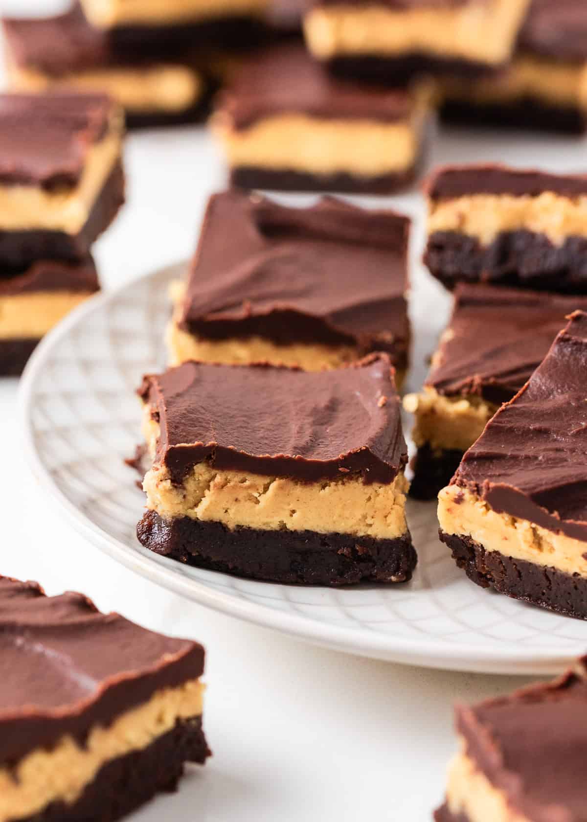 Plate of buckeye brownies with fudgy chocolate brownie, peanut butter filling and ganache topping.