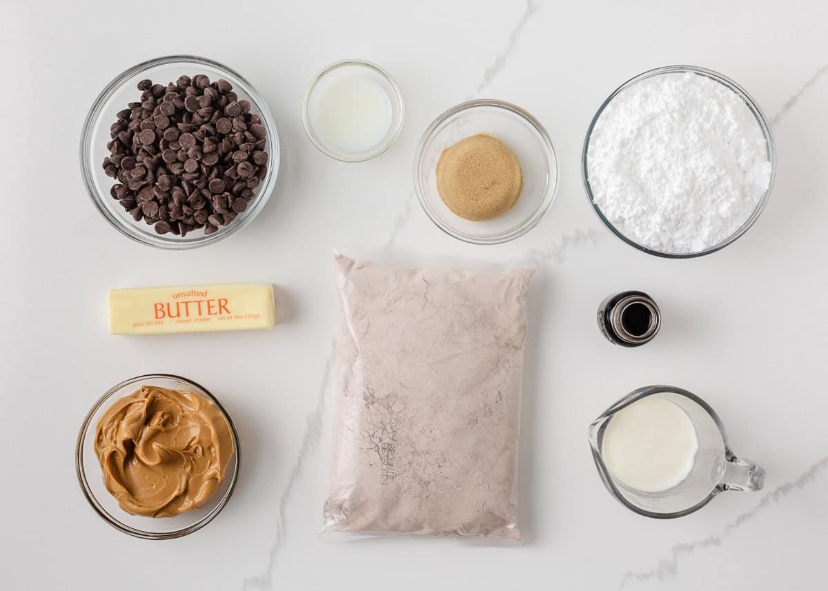 Ingredients for buckeye brownies including brownie mix, peanut butter, chocolate chips, butter, powdered sugar and cream.