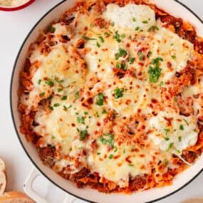 One pan skillet lasagna baked with bowtie pasta, rich meat sauce, ricotta, and bubbly golden mozzarella cheese.