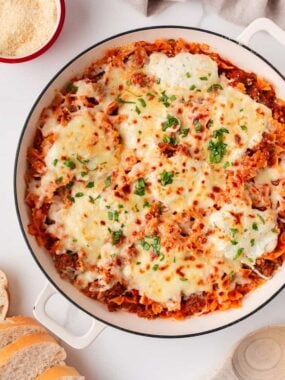 One pan skillet lasagna baked with bowtie pasta, rich meat sauce, ricotta, and bubbly golden mozzarella cheese.