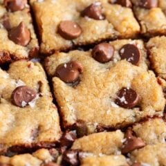 Overhead of chocolate chip cookie bars sliced into squares with melty chocolate chips.