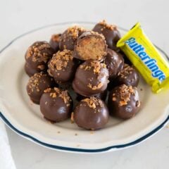 Butterfinger balls on a plate with a butterfinger candy bar.
