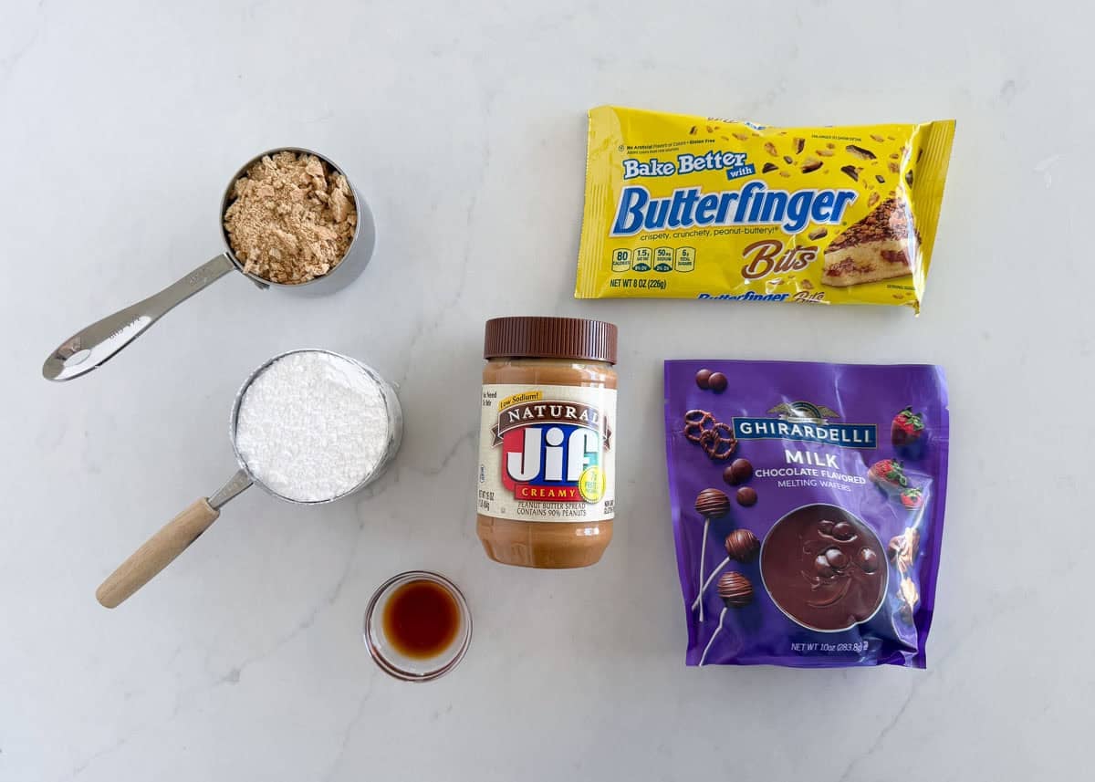 These Butterfinger balls are bite-sized no-bake truffles with crushed Butterfinger candy and graham crackers folded into the filling, then dipped in chocolate. An irresistible sweet treat! Butterfinger ball ingredients including butterfinger bits, crushed graham crackers, powdered sugar, peanut butter and milk chocolate wafers.