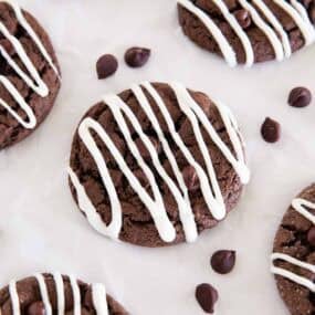 Soft chocolate cake mix cookies covered with white chocolate drizzle and chocolate chips.