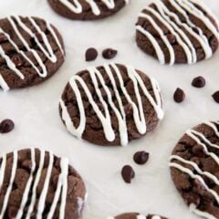 Chocolate cake mix cookies drizzled with white chocolate and scattered with chocolate chips.