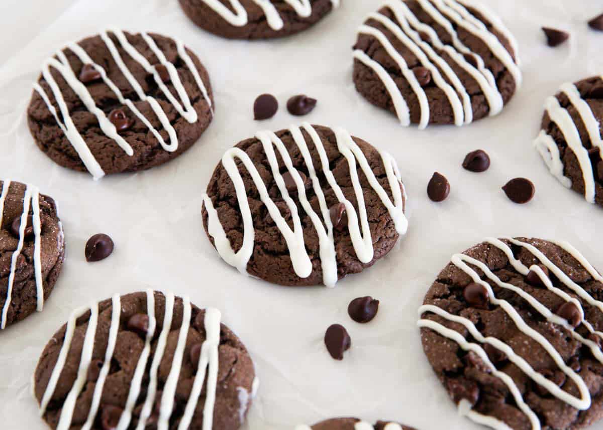 Chocolate cake mix cookies drizzled with white chocolate and scattered with chocolate chips.