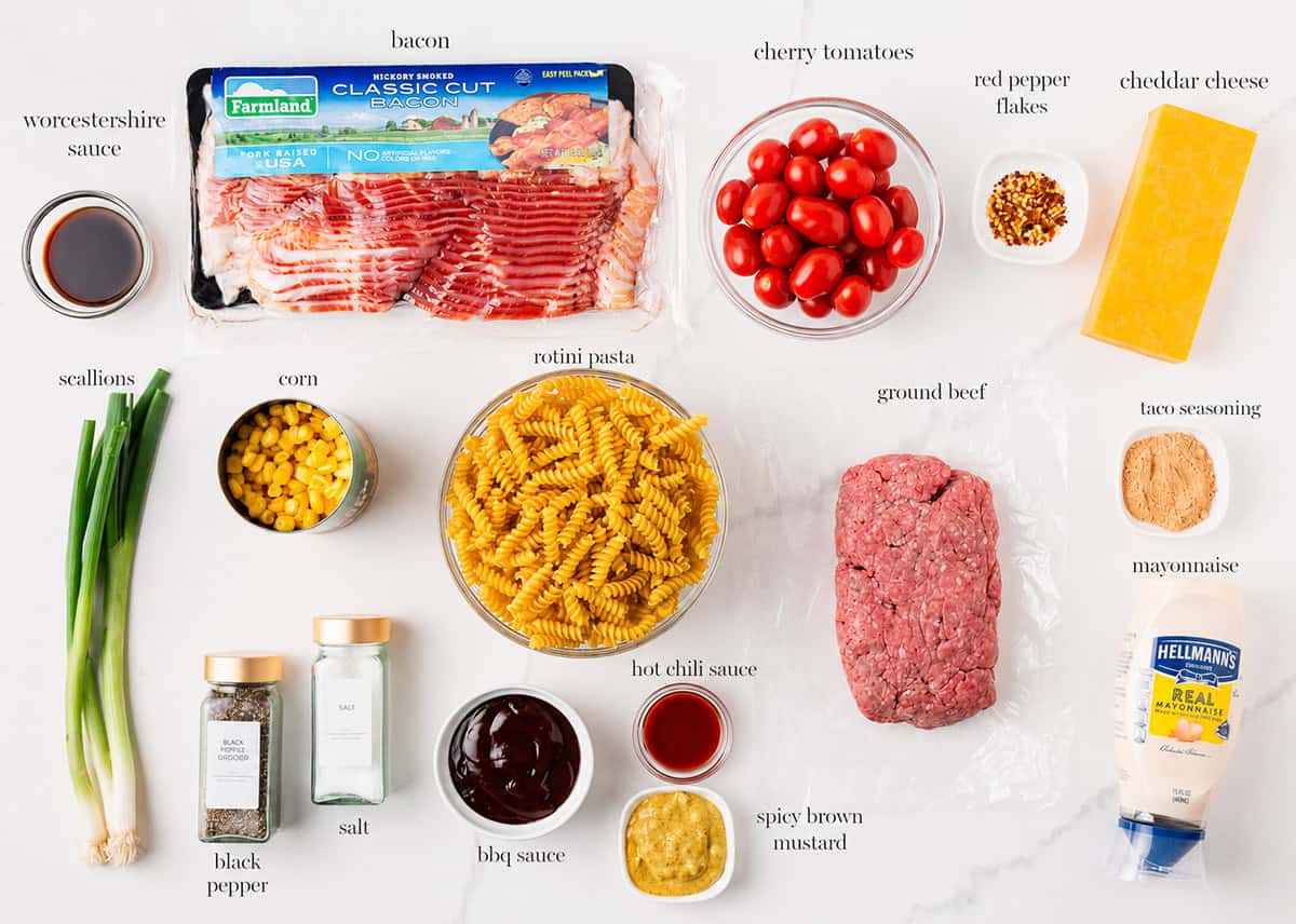 Packed with bold flavors in every bite, this cowboy pasta salad is made with tender noodles, bacon, seasoned ground beef, a creamy dressing, and Southwestern flavor! Cowboy pasta salad ingredients including rotini, ground beef, bacon, cherry tomatoes, corn, cheddar cheese, and condiments.