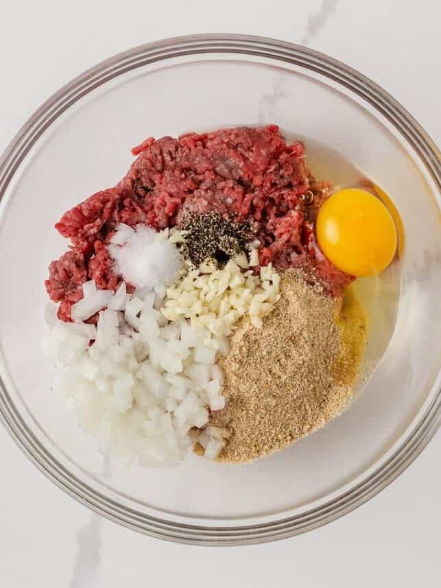 Ground beef mixed with egg, breadcrumbs, onion, garlic, salt and pepper for homemade meatballs.