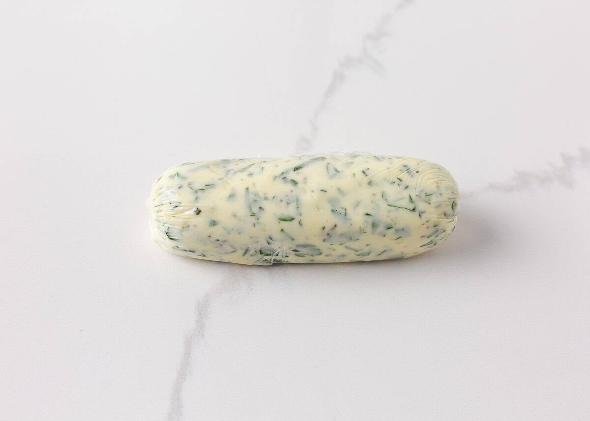 Homemade garlic herb butter rolled into a log and chilled for grilled steak.