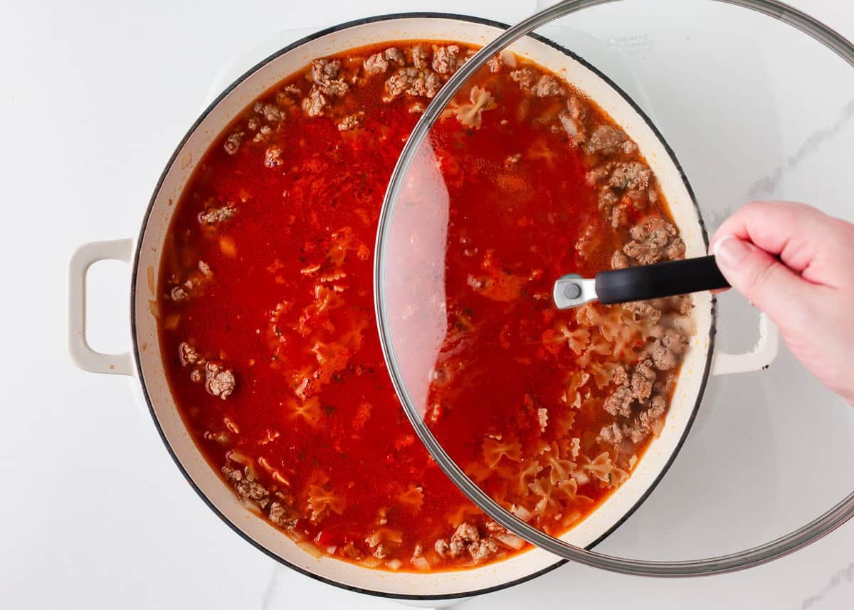 This easy one-pan skillet lasagna comes together on the stovetop in under an hour, with the same bubbly, saucy, cheesy comfort of the classic baked version. Covering skillet lasagna with lid to simmer pasta until tender in a one pan meal.